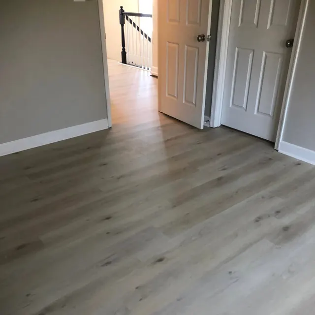 Grey luxury vinyl plank floor running through a hallway and doorway