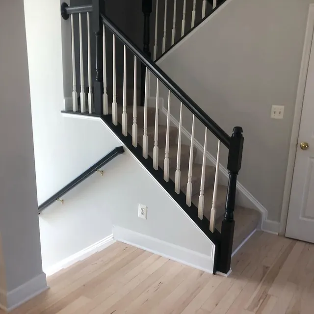 Light oak floor and stairs with a black iron railing