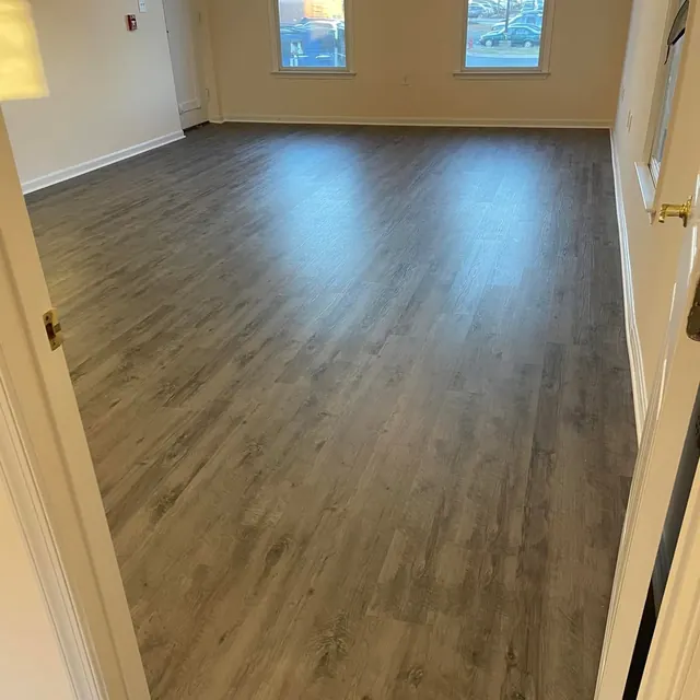 Grey luxury vinyl plank floor in a room with windows