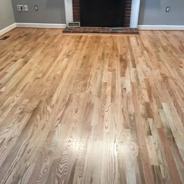 Red oak floor in a natural finish beside a brick fireplace