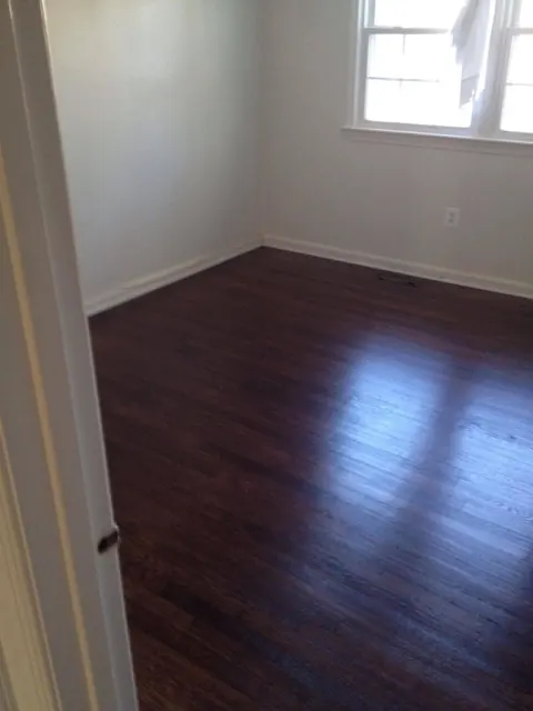 The same bedroom with the oak floor sanded and stained dark